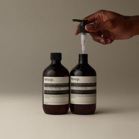 Aesop A Rose By Any Other Name Body Cleanser with floral background