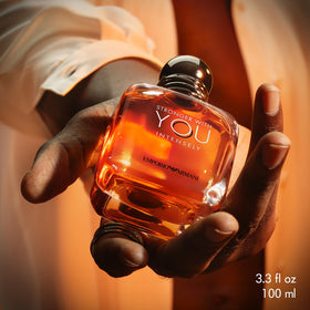 Armani Beauty Stronger With You Intensely cologne on a wooden surface