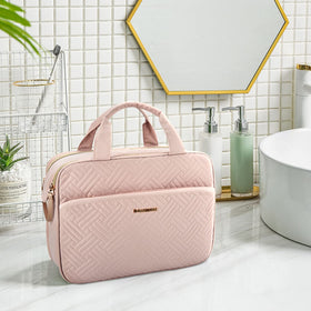 BAGSMART toiletry bag in pink on a bathroom counter