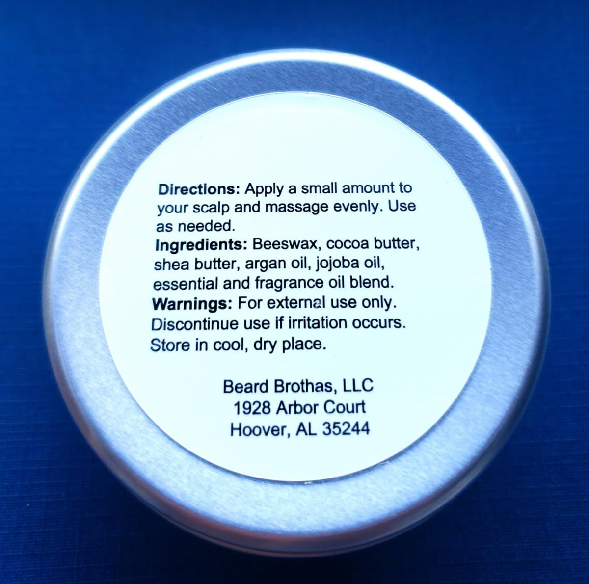 Bald Head Moisturizer with leather and cedar background