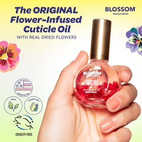 Blossom Cuticle Oil in hand with natural flowers background