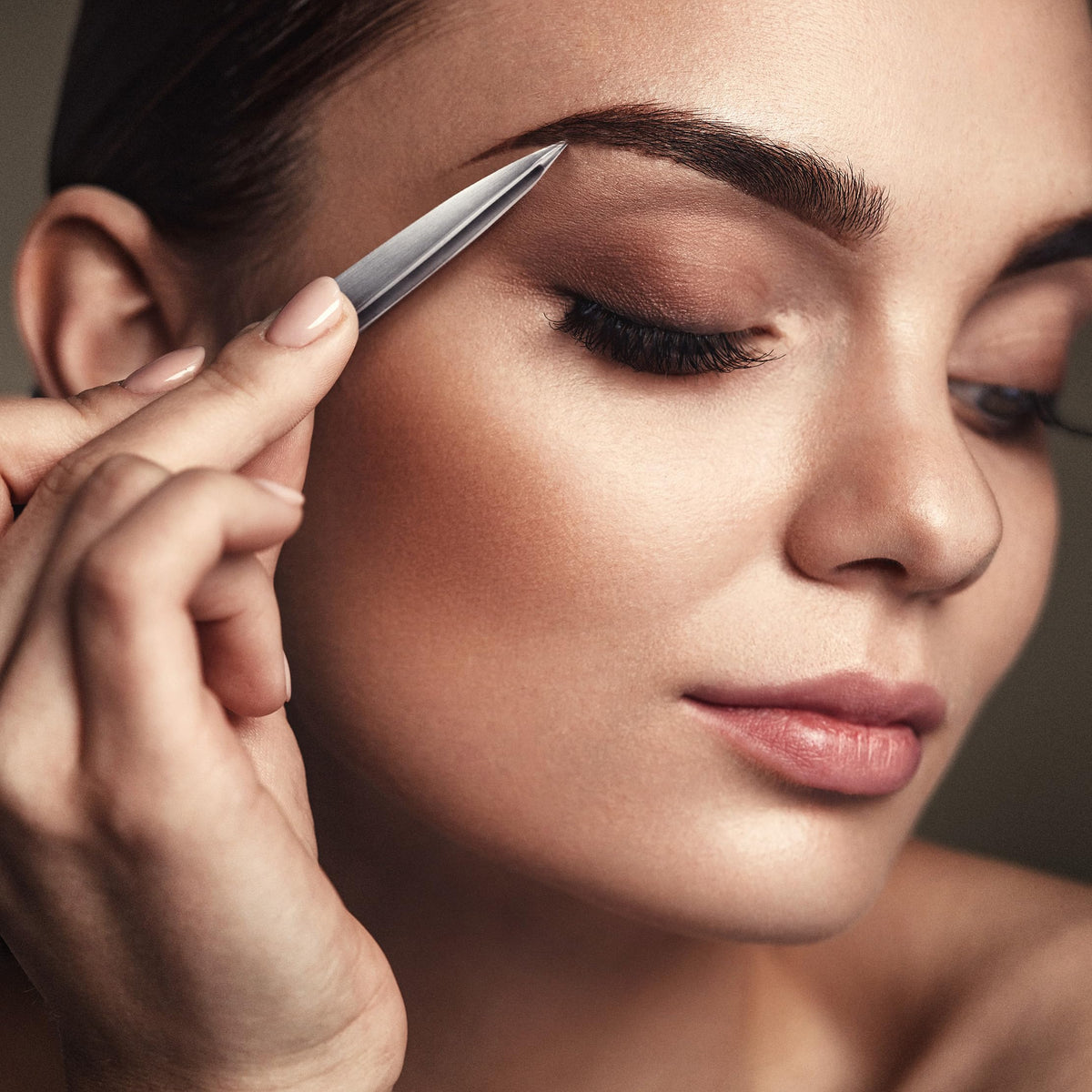 By MILLY Pointed Tweezers on a vanity with beauty products