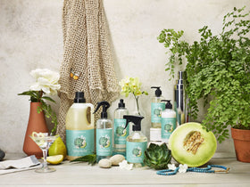 Caldrea Pear Blossom Agave Hand Soap with a floral background