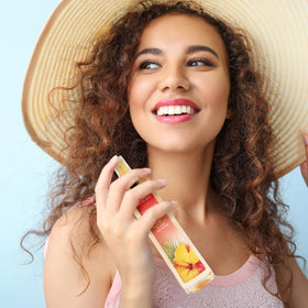 Calgon Hawaiian Ginger Body Mist surrounded by tropical fruits