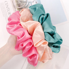 CEELGON scrunchies in various colours laid out on a surface
