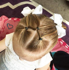CÉLLOT hair bows on a child's head styled in pigtails