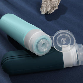 CHEODIN travel bottles arranged stylishly on a travel suitcase