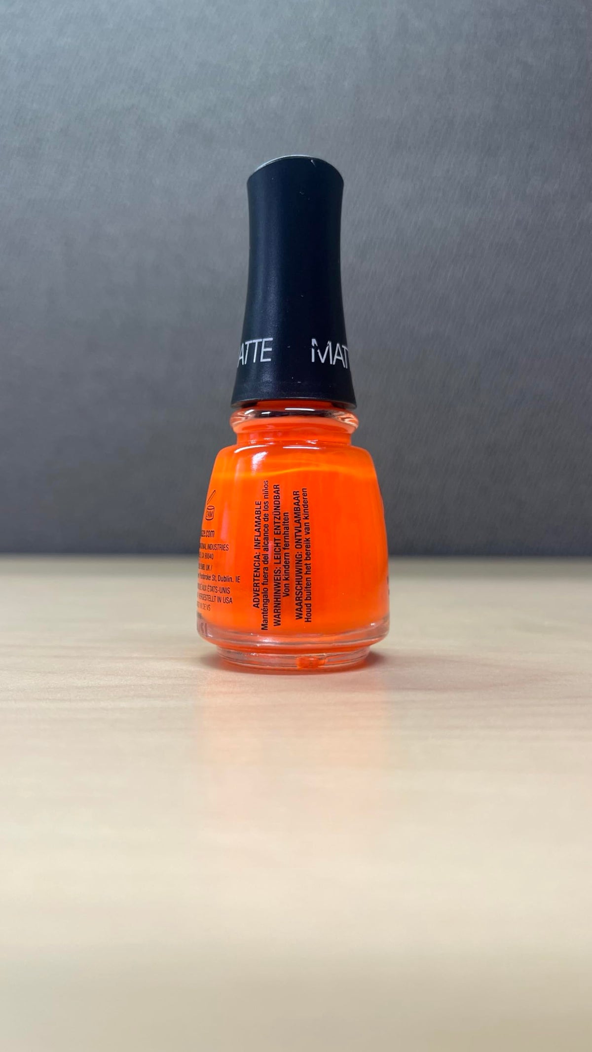 China Glaze Orange Knockout Nail Lacquer on a manicure table