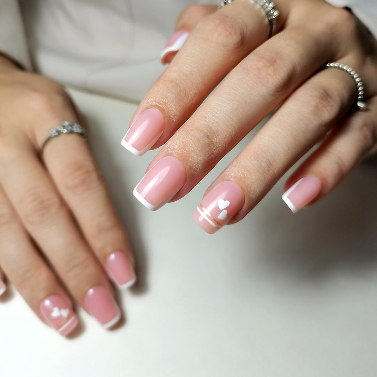 Close-up of CurvLife French Tip Press On Nails with nail glue and accessories