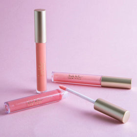 Close-up of Nicole Miller lip gloss tubes showing shimmery finishes