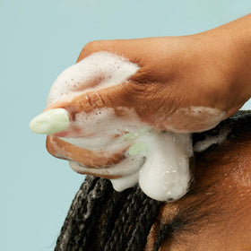 Close-up of PATTERN Curl Mousse foam on hand
