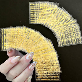 Close-up of SPLOCUDU gold lace nail stickers on a nail