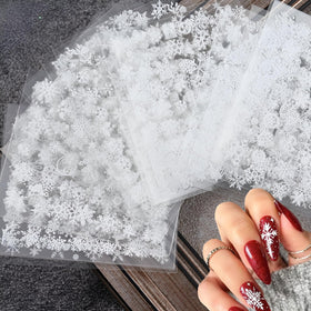 Close-up of SPLOCUDU snowflake nail stickers in white