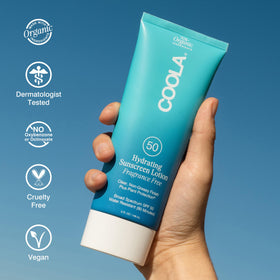 COOLA Hydrating SPF 50 Sunscreen Lotion packaging on a beach
