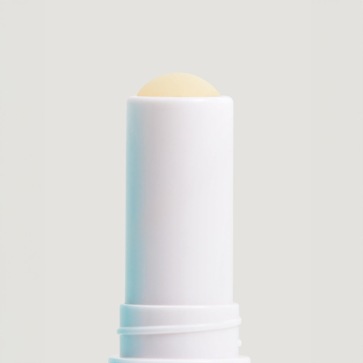 COOLA Liplux SPF 30 Organic Lip Balm with ocean background