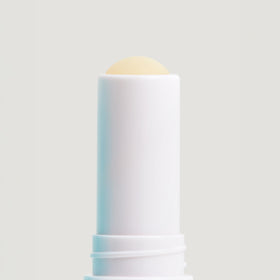 COOLA Liplux SPF 30 Organic Lip Balm with ocean background