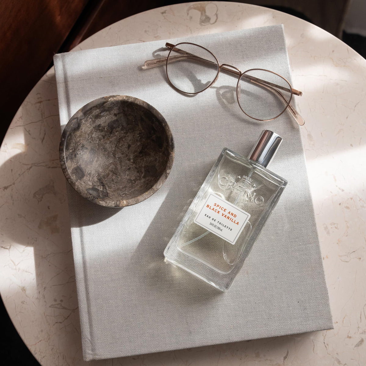 Cremo Spice & Black Vanilla Cologne on wooden surface