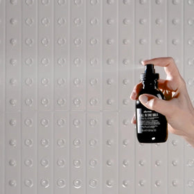 Davines OI Shampoo pouring out of the bottle
