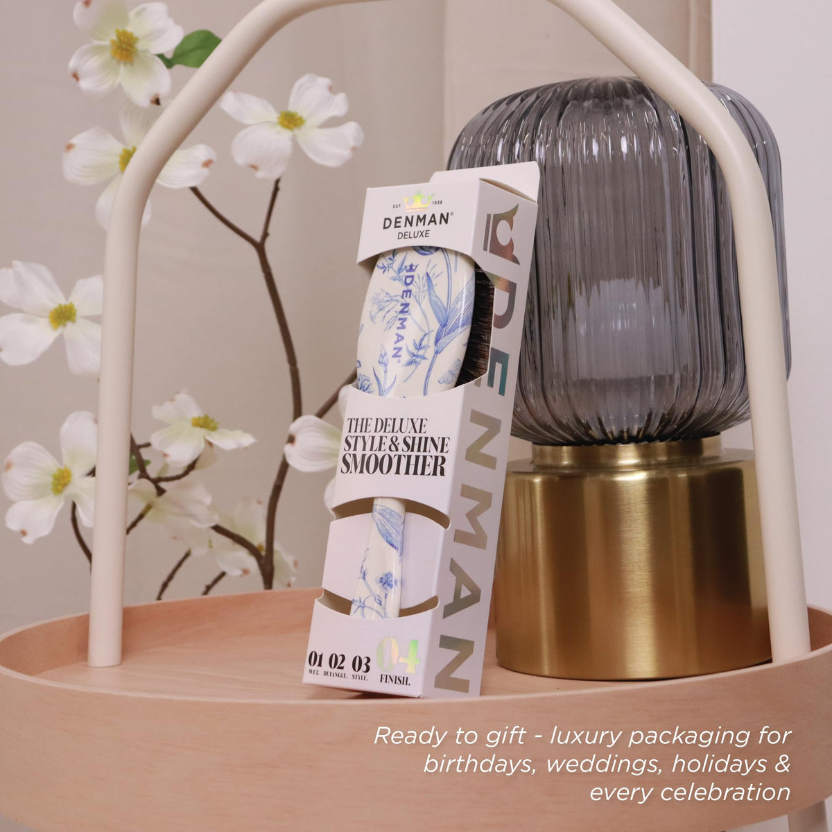 Denman Boar Bristle Hair Brush on a vanity with hair products