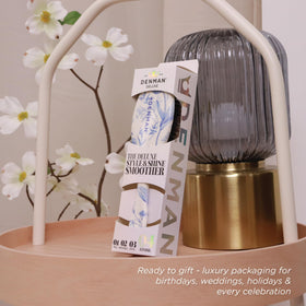 Denman Boar Bristle Hair Brush on a vanity with hair products