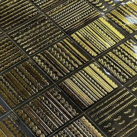 Different styles of SPLOCUDU gold nail stickers laid out