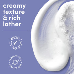 Dove Serum Body Wash Calming Moisture packaging with oat milk background