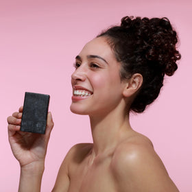 Dr. Natural Black Bar Soap on a soap dish