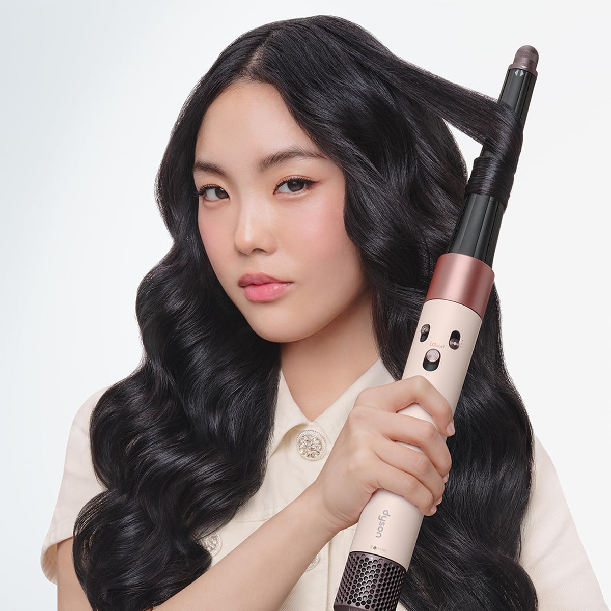 Dyson Airwrap i.d. Multi-Styler with app interface on smartphone