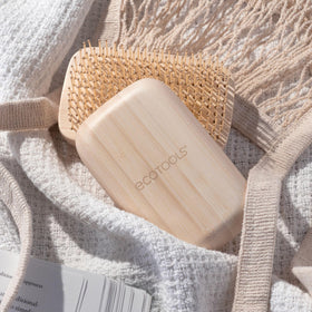 EcoTools Travel Detangler Hairbrush displayed on a vanity