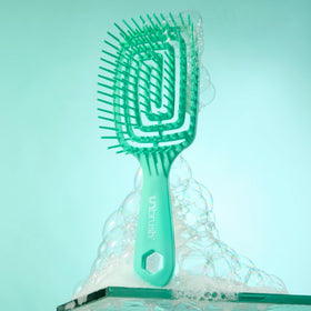 FHI Heat UNbrush Flex Detangling Brush in a stylish bathroom setting