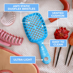 FHI Heat UNbrush Mini Detangling Brush on a travel bag