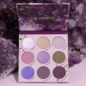 Flat lay of ColourPop All Amethyst Eyeshadow Palette with brushes