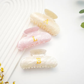 Fohufo Acrylic Letter Hair Clip displayed in luxurious velvet bag