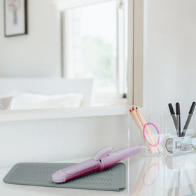 Fouews Silicone Heat Resistant Mat on a countertop with hair tools