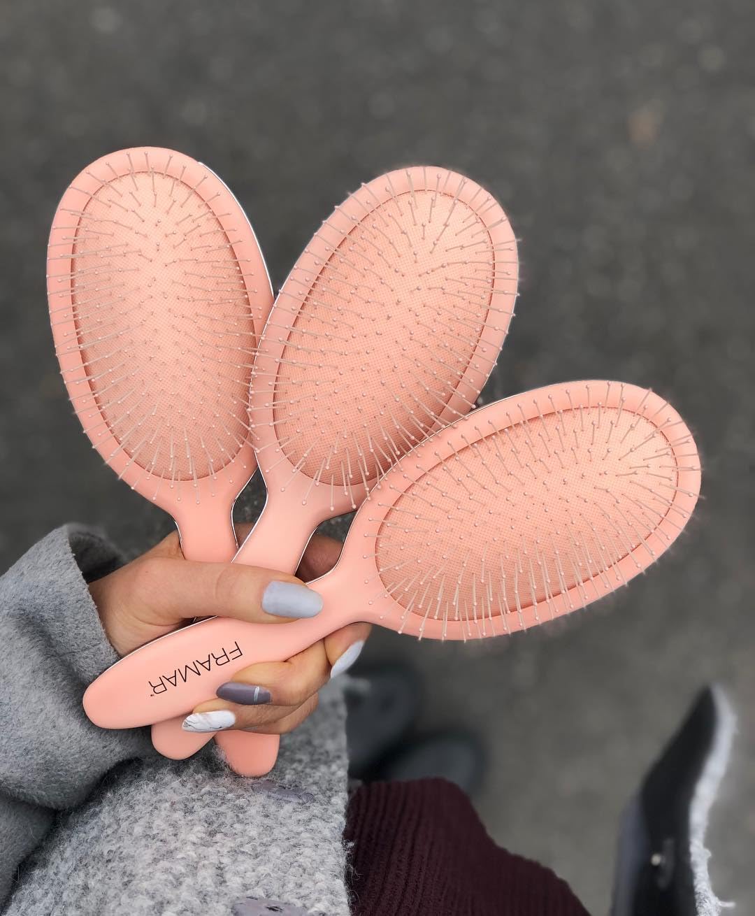 FRAMAR Detangling Brush displayed with hair products
