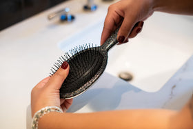 FRAMAR Glitter Hair Brush Detangler in hand during use