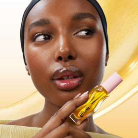 Gisou Honey Infused Lip Oil in hand, showcasing glossy finish