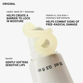Glossier Balm Dotcom Lip Balm on a wooden surface, lifestyle shot
