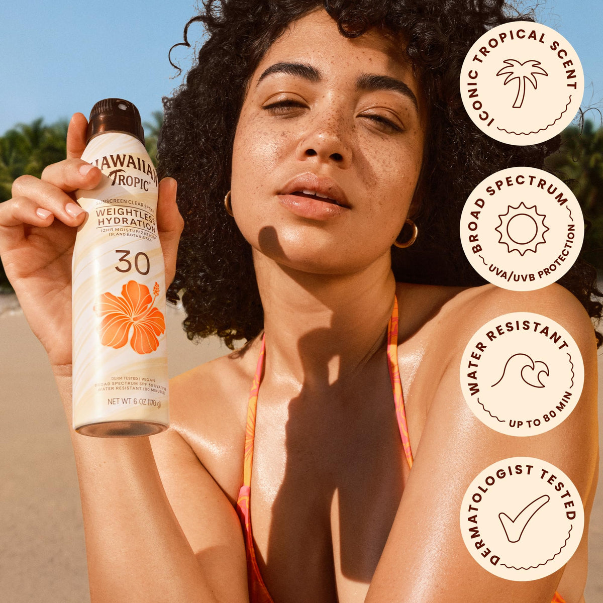 Hawaiian Tropic sunscreen spray in tropical setting
