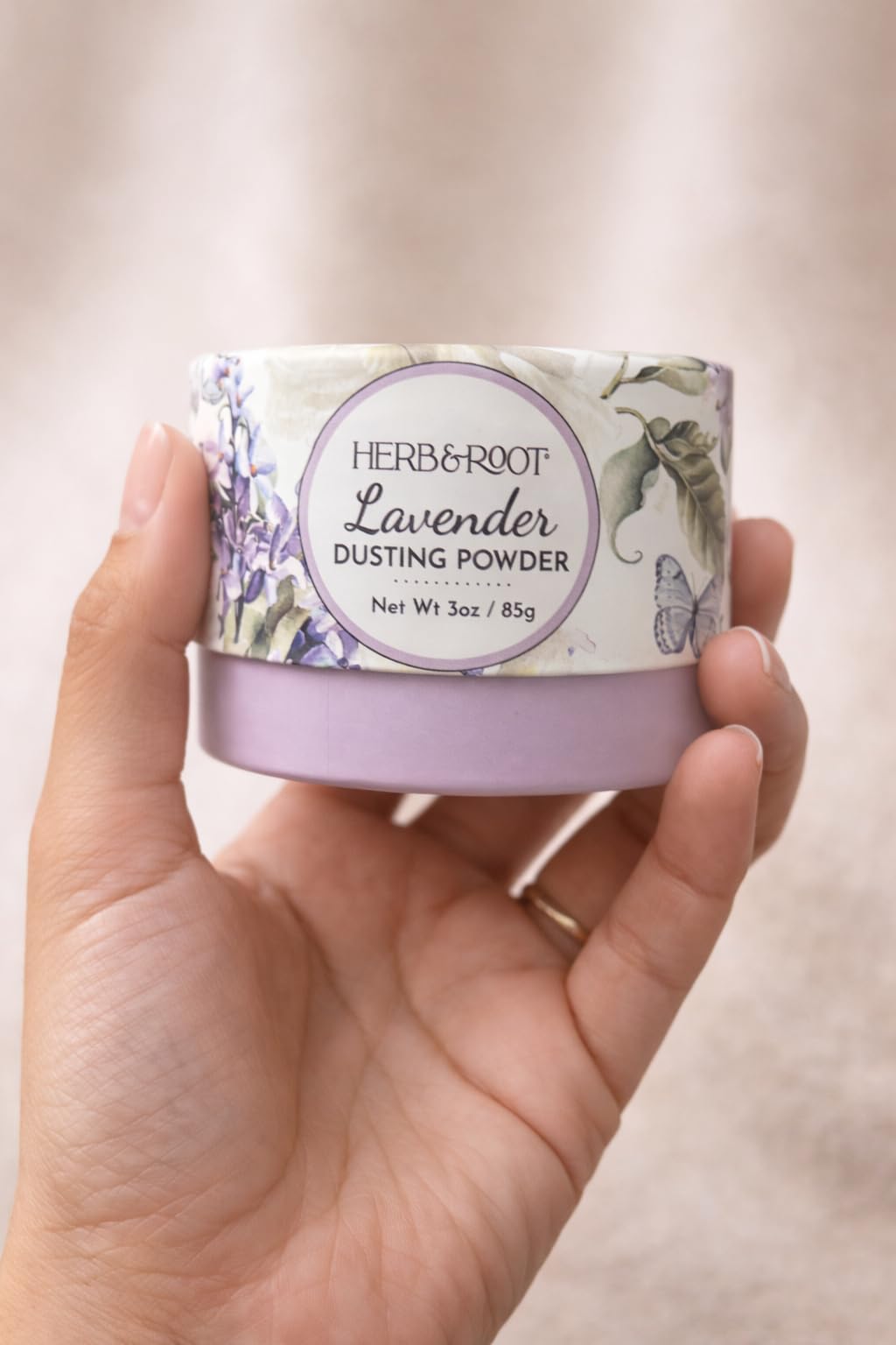 Herb & Root Lavender Dusting Powder 2 oz on a travel bag