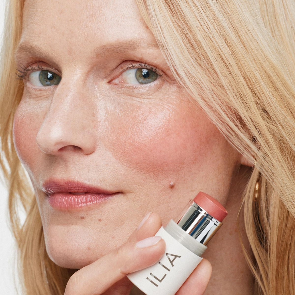 ILIA Multi-Stick Cheek + Lip Color All Of Me Watermelon Pink on a makeup table