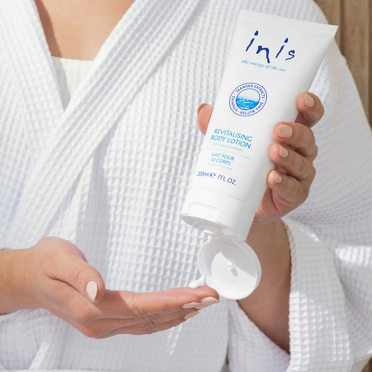 Inis Revitalizing Body Lotion on a bathroom counter