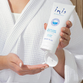 Inis Revitalizing Body Lotion on a bathroom counter