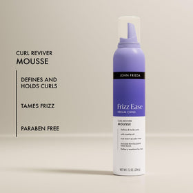 John Frieda Curl Reviver Mousse in hand, applying to hair
