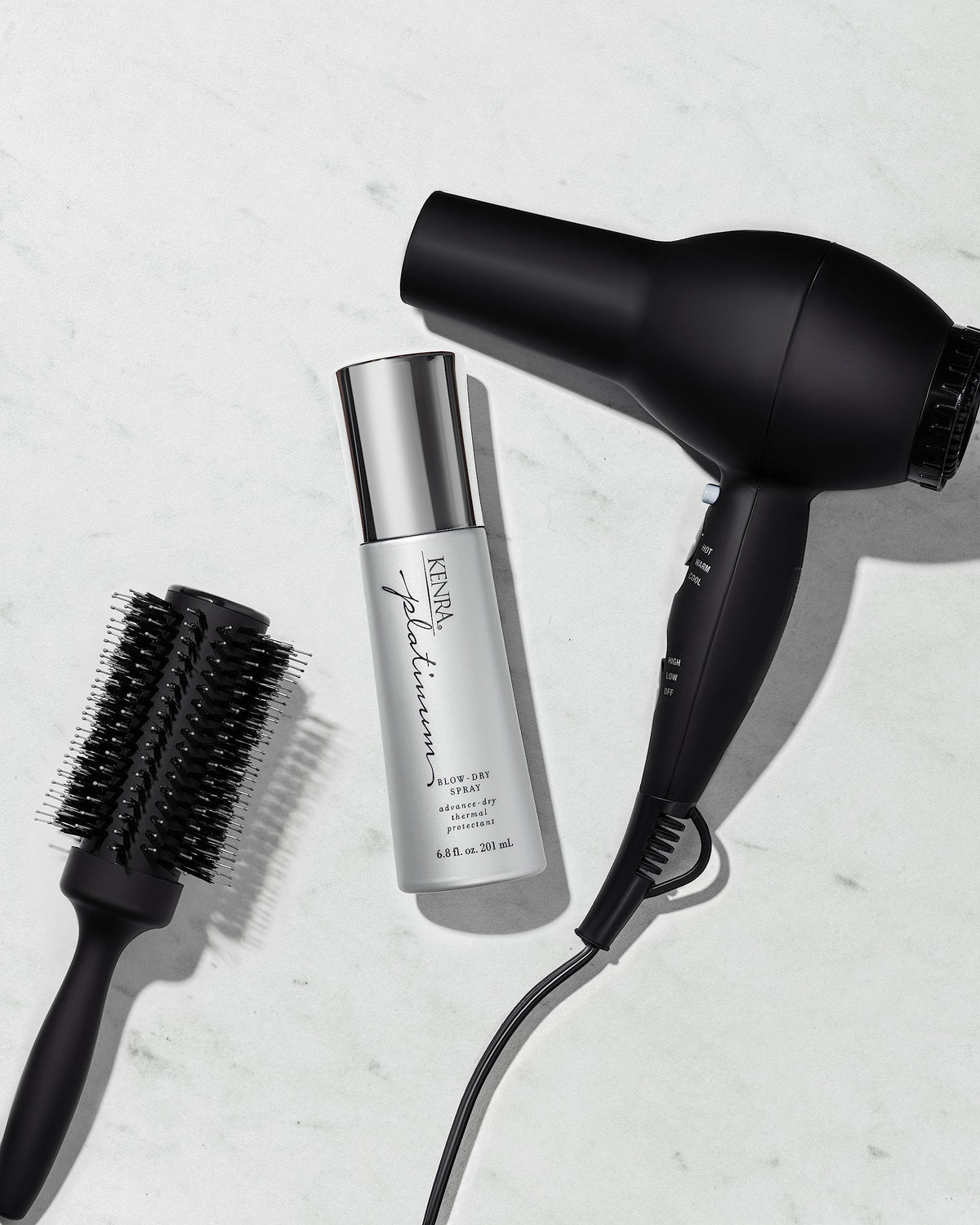 Kenra Platinum Blow-Dry Spray bottles with hair styling tools