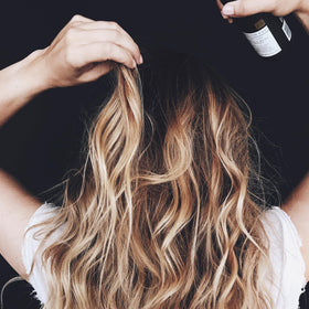 Kristin Ess Beach Wave Hair Spray 6.7 oz on vanity