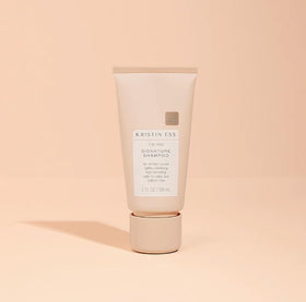 Kristin Ess mini shampoo and conditioner set on a travel bag