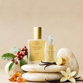 Kuumba Made Vanilla Bean Fragrance Oil Roll-On surrounded by vanilla beans