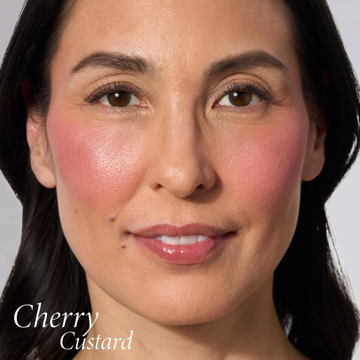 LAURA GELLER Baked Blush-n-Brighten Cherry Custard on a makeup vanity