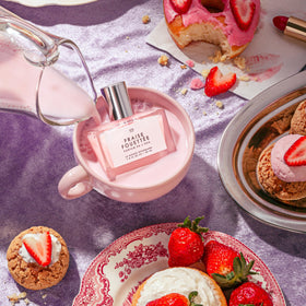 Le Monde Gourmand Fraise Fouettée Eau de Parfum surrounded by flowers